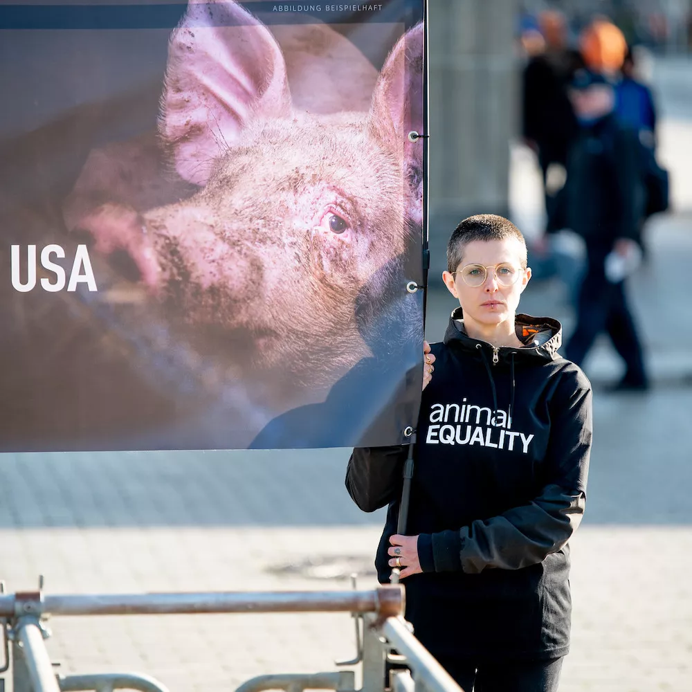 Animal Equality activist holding a banner during a protest